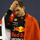 Max Verstappen, draped in a flag, his hand on his head.